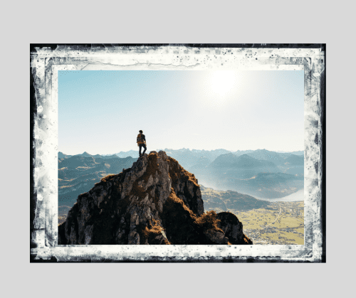 Silhouette of a man standing near the top of a mountain on a bright, sunny day. Meant to signify how men can start a positive new chapter after divorce. 