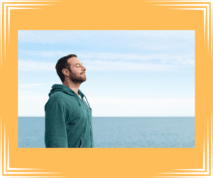 Relaxed man taking a deep breath at the beach. 